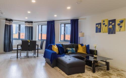 a living room with a blue couch and a table at Virexxa Bedford Centre - Alpha Suite - 2Bed Flat with Free Parking & Gym in Bedford