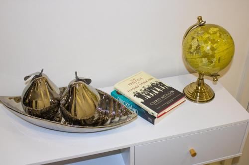 a table with a plate and a book and a globe at Virexxa Bedford Centre - Alpha Suite - 2Bed Flat with Free Parking & Gym in Bedford