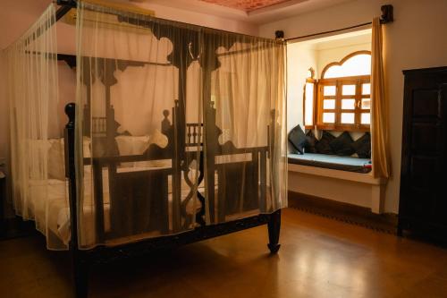 a bedroom with a canopy bed and a window at Jaisalmer Elite Castle in Jaisalmer