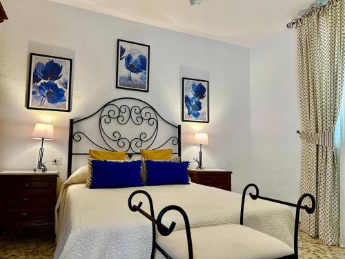 a bedroom with a large bed with blue pillows at La casa de mis padres in Júzcar