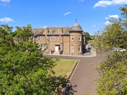 an old stone house with a roof at Panmure Apartment in Monifieth