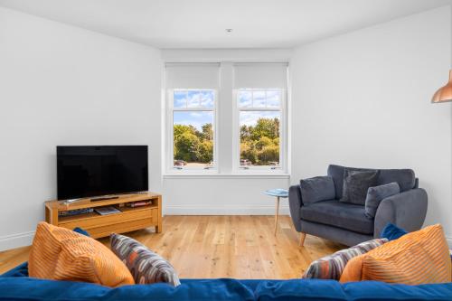 a living room with a couch and a television at Panmure Apartment in Monifieth