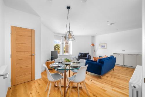 a living room with a table and chairs and a blue couch at Panmure Apartment in Monifieth
