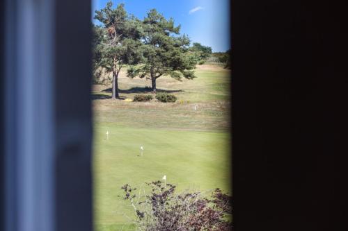 a view of a golf course with a tree at Panmure Apartment in Monifieth