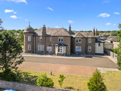 an aerial view of a large brick house with a driveway at Panmure Apartment in Monifieth