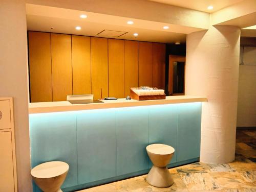 a kitchen with a blue counter with two stools at Nesthotel alt Kawasaki Station in Kawasaki
