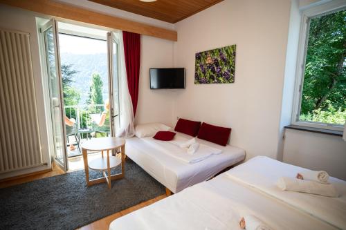 a hotel room with two beds and a window at Villa Marienhof in Annenheim
