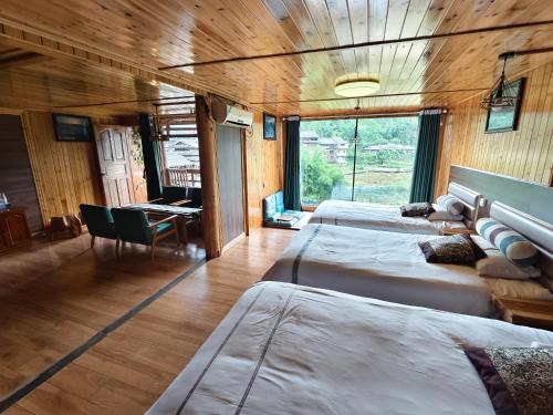 a bedroom with two beds in a room with a desk at Bridge View Boutique Guesthouse 望桥楼精品民宿 in Sanjiang