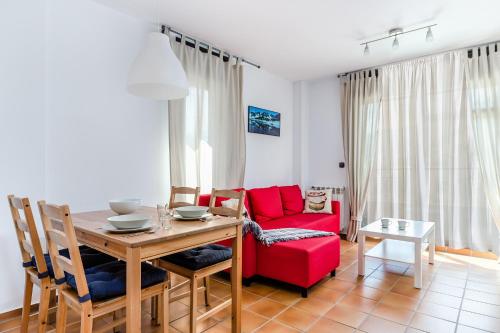 a living room with a table and a red couch at Apartamentos Prat de les Molleres in Soldeu