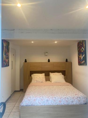 une chambre avec un grand lit avec une tête de lit en bois dans l'établissement Superbe séjour chez Renaud, à Obenheim