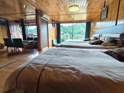 a bedroom with two large beds and a dining room at Bridge View Boutique Guesthouse 望桥楼精品民宿 in Sanjiang