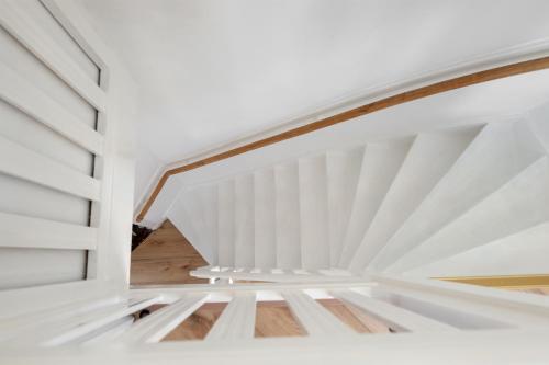 a staircase in a house with white walls and wood floors at De Hill Rotterdam in Rotterdam