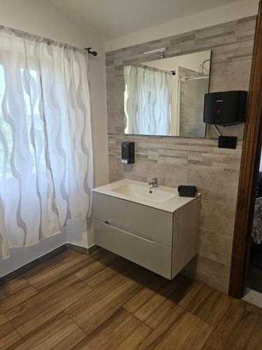 a bathroom with a sink and a mirror at Regina Margherita affittacamere in Aulla