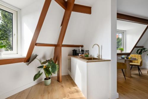 a kitchen with white walls and wooden beams at De Hill Rotterdam in Rotterdam