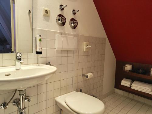 a bathroom with a white toilet and a sink at WHLIVING - Apartments & Studios in Konstanz in Konstanz