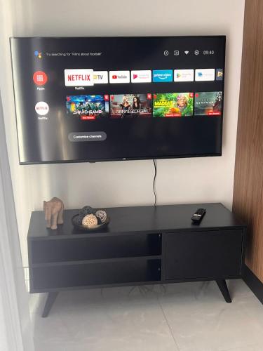 a black entertainment center with a tv on a wall at Stylish 2-bedroom Apartment- near Valletta! Great for families or groups in Gwardamanġa
