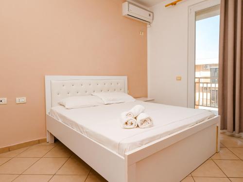 a bedroom with a white bed with towels on it at Queen Residence in Shëngjin