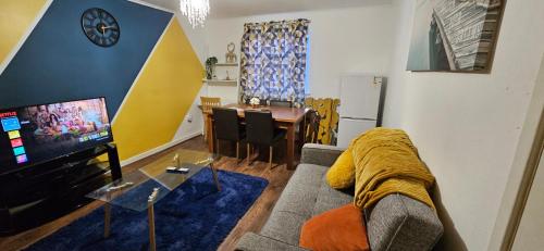 ein Wohnzimmer mit einer Couch, einem Fernseher und einem Tisch in der Unterkunft OG Stays III- 6bedroom house- sleeps 9persons, Near Nissan & Stadium of Light, free parking in Pallion