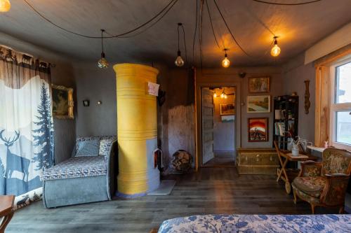 a room with a large yellow column in a room at Private Farm Jakuzzi Sauna in the forest in Talsi