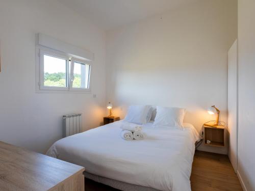 a bedroom with a white bed with two stuffed animals on it at Ty Ker by Madame Est Servie in Pleumeur-Bodou