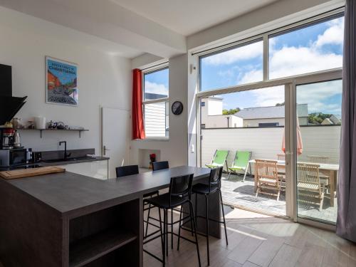 une cuisine et une salle à manger avec une grande fenêtre dans l'établissement Ty Ker by Madame Est Servie, à Pleumeur-Bodou