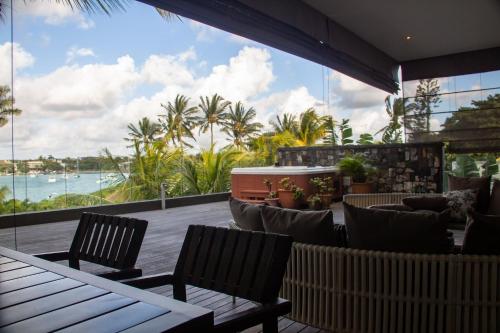 a patio with chairs and tables and a view of the ocean at Beachfront Penthouse 3 bedrooms - Grand Baie Mauritius in Grand Baie