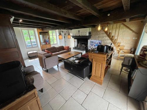 a living room with a couch and a table at Maison Neuve, relaxing countryside home with pool in Chillac