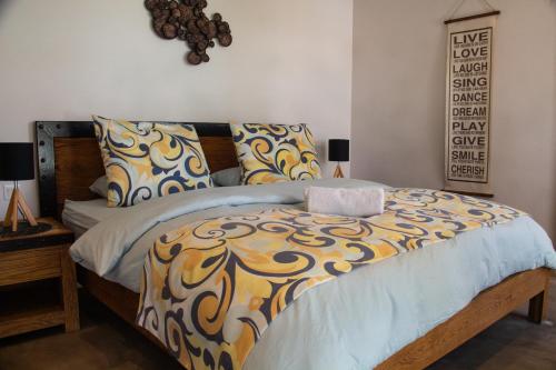 a bedroom with a bed with a yellow and blue comforter at Beachfront Penthouse 3 bedrooms - Grand Baie Mauritius in Grand Baie