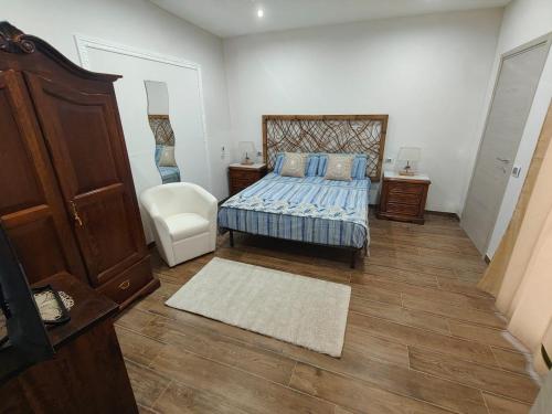a bedroom with a bed and a chair at La dimora di Lorenzo in Giurdignano