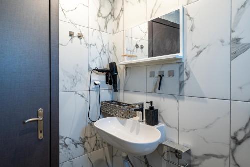 a white bathroom with a sink and a mirror at Relaxrooms in Lefkímmi