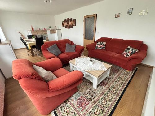 a living room with two red couches and a coffee table at Dům v Českém ráji in Dolní Bousov