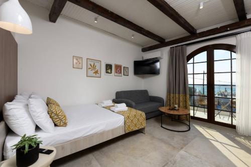 a bedroom with a bed and a couch and a chair at Sea View Center in Limenas