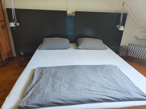 a large bed with two pillows on top of it at WHLIVING - Apartments & Studios in Konstanz in Konstanz