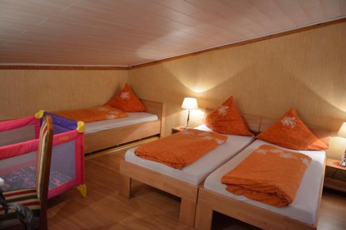a bedroom with two beds with orange pillows at Romantik-Pension Vogt in Offenburg