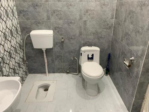 a bathroom with a toilet and a sink at Luxurious 5 Bedroom Mansion Upper Portion Near Gerry Visa Park Road Islamabad in Islamabad