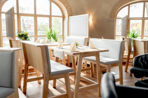 a table and chairs in a room with windows at Hotel Donau-Ries in Mertingen