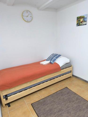 a bed in a room with a clock on the wall at E-Tekergők Háza in Bükkzsérc