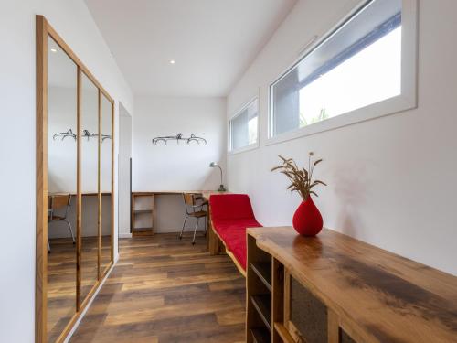 a living room with a red couch and a window at Le Gwern by Madame est Servie in Pleumeur-Bodou
