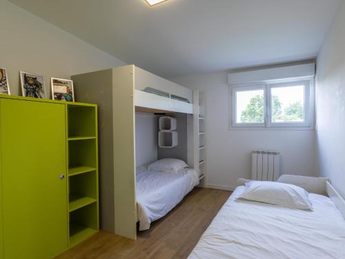 - une chambre avec 2 lits et une armoire verte dans l'établissement Le Gwern by Madame est Servie, à Pleumeur-Bodou