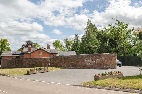 a brick wall in front of a house at The Hurst Coach House in Stafford