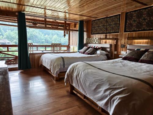 a bedroom with two beds and a large window at Bridge View Boutique Guesthouse 望桥楼精品民宿 in Sanjiang