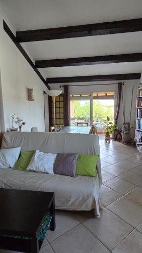 a living room with a couch with green pillows at Appartement spacieux, haut de villa, 3 chambres, 100 m2, 6 personnes, au calme in Six-Fours-les-Plages