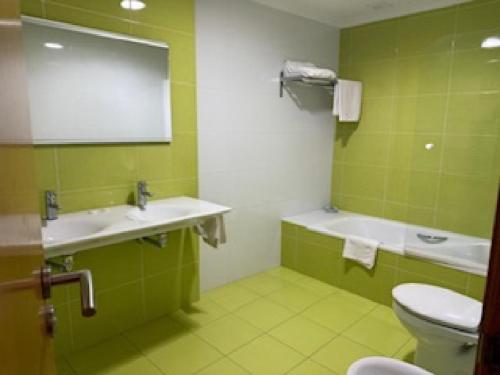 zielona łazienka z toaletą i umywalką w obiekcie Hostal Restaurante Pinarejo w mieście A Lanzada