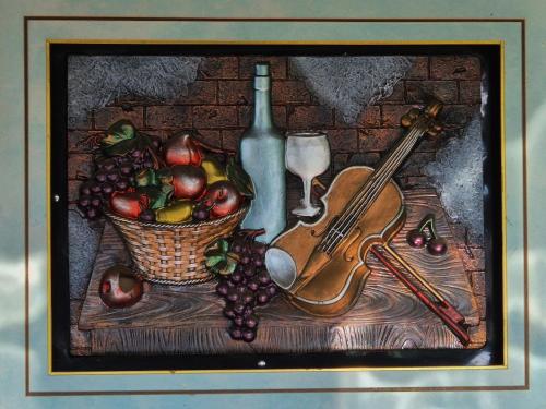 a painting of a violin and a basket of fruit at La Nelutu Ceterasu in Ocna Şugatag