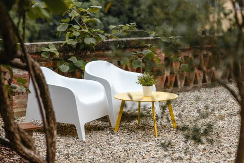 two white chairs and a table with a potted plant at Casa Victoria in Spigno Monferrato