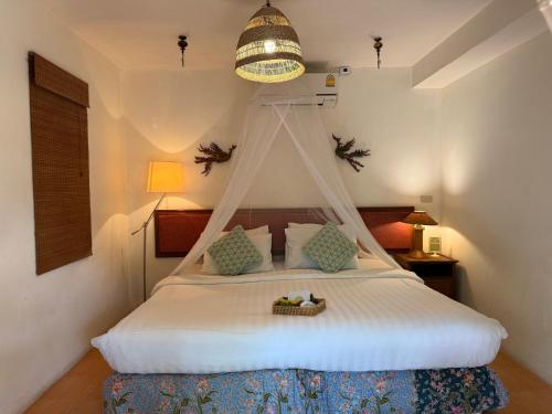 ein Schlafzimmer mit einem Himmelbett in der Unterkunft Natural Wing Health Spa and Resort in Ban Bang Po