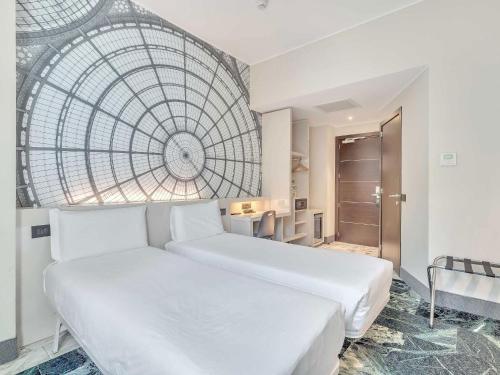 a bedroom with two beds and a large window at B&B Hotel Milano Sant'Ambrogio in Milan