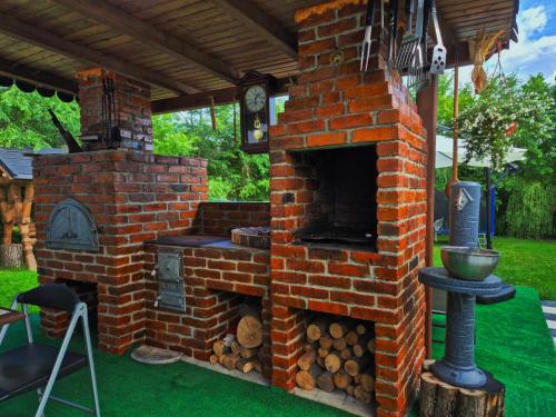 an outdoor brick oven with a clock on top at La Nelutu Ceterasu in Ocna Şugatag