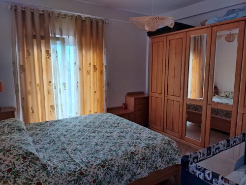 a bedroom with a bed and a wooden cabinet at EraDeo Apartment Golem in Golem