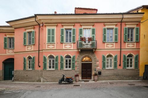 a pink building with a scooter parked in front of it at Casa Victoria in Spigno Monferrato